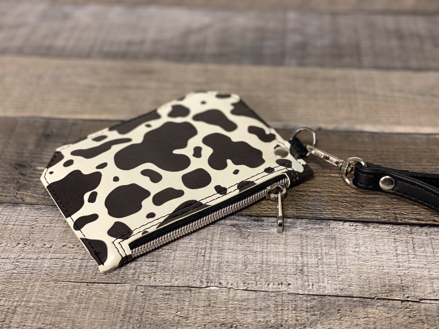 Black and white cow print purse pal wristlet wallet back panel view.