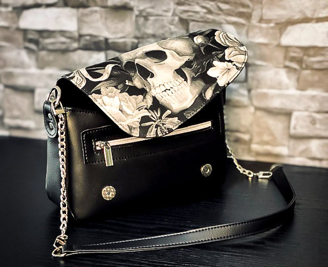 Black faux leather handbag with a black and white skull cotton canvas flap. 