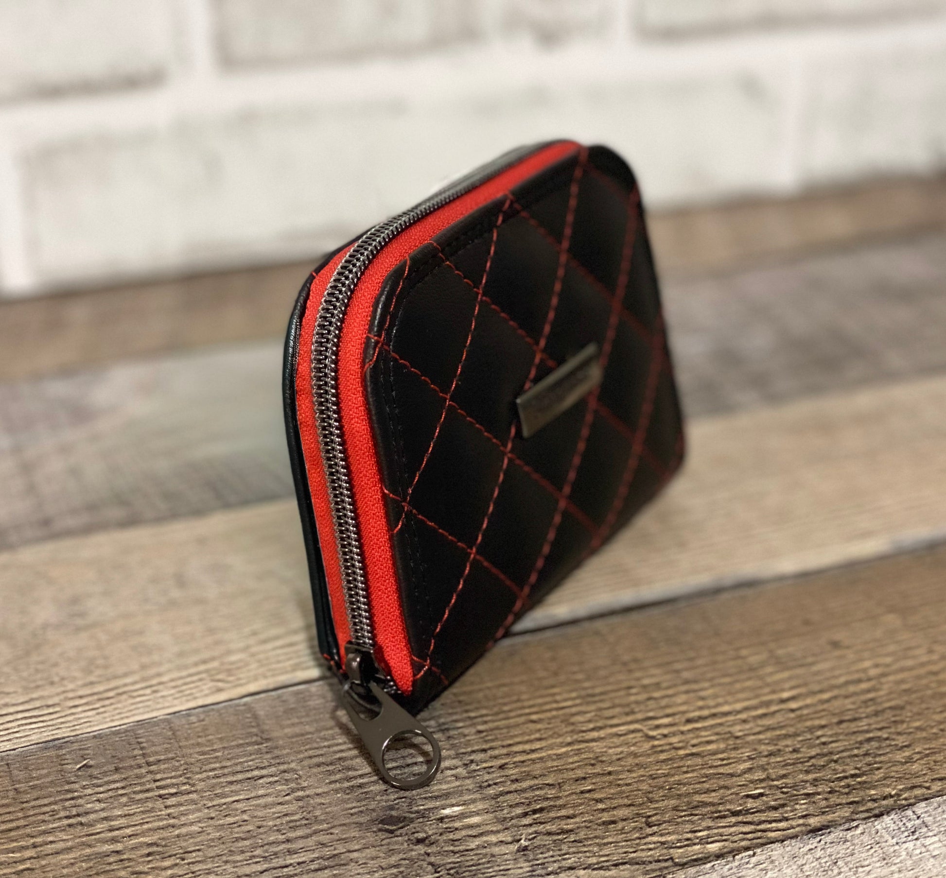 Black faux leather with quilting with red thread. Front and side view. 