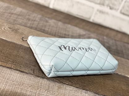 Baby blue quilted pouch with the word mama embroidered in the center. Side panel