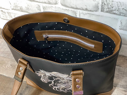 Black and brown hand bag with embroidered horse head. Showing black and white polkadot cotton lining and brown zipper overlay. 