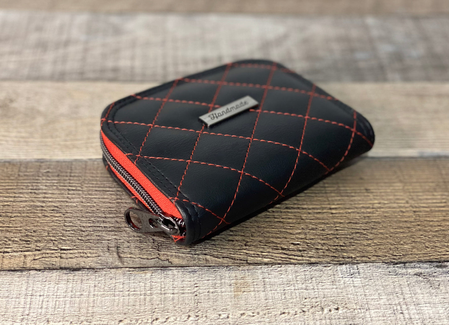 Black faux leather with quilting with red thread. Front and side view. 