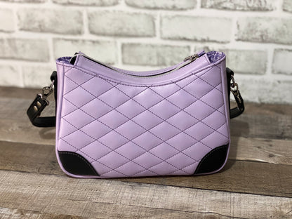 Quilted lilac purple handbag with black accents. Back view