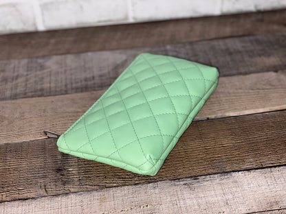 Side view of mint green quilted pouch.