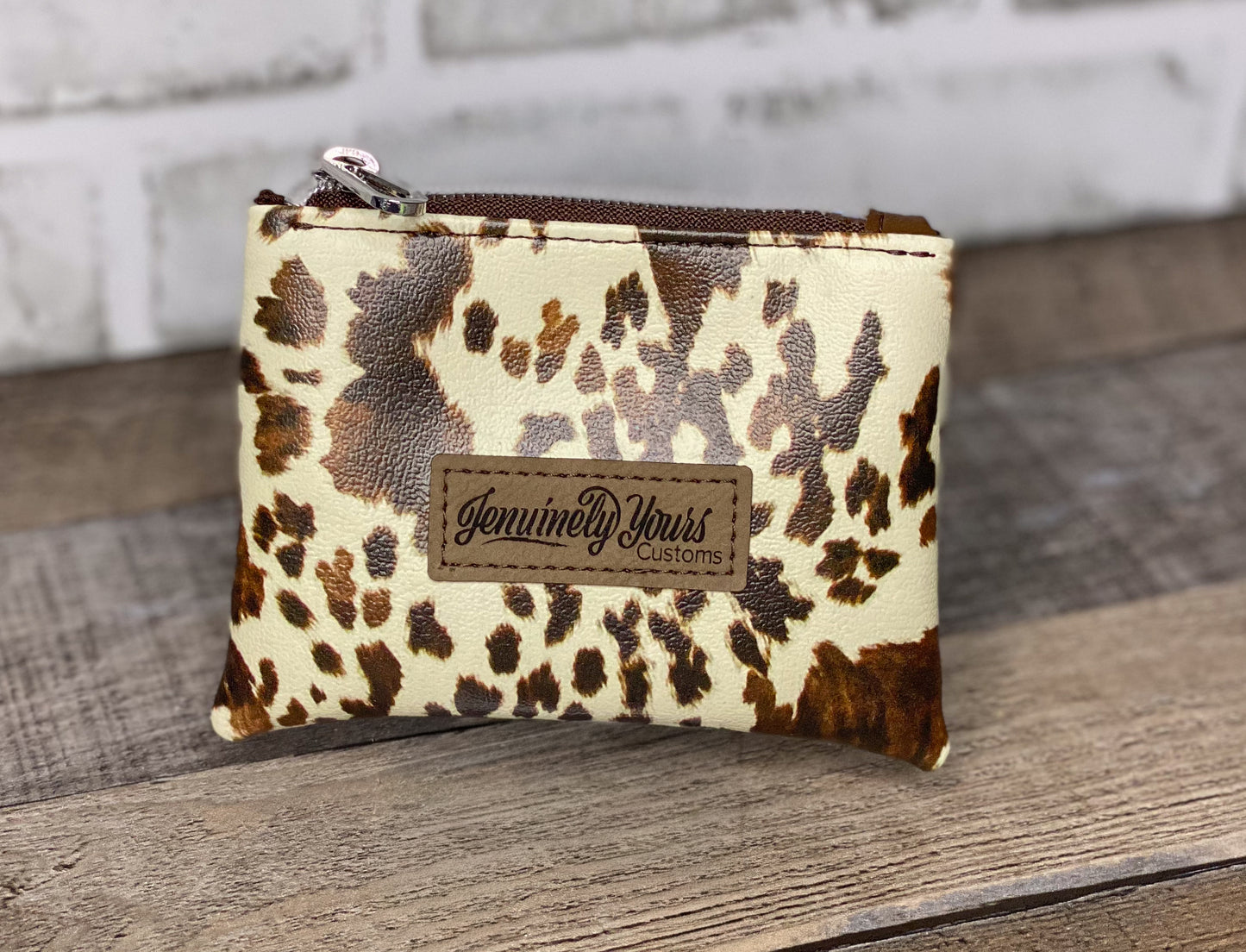 Mini faux leather cow print pouch.