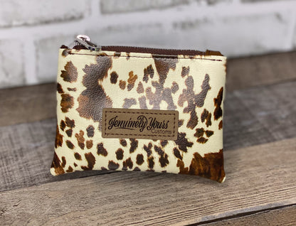 Mini faux leather cow print pouch.
