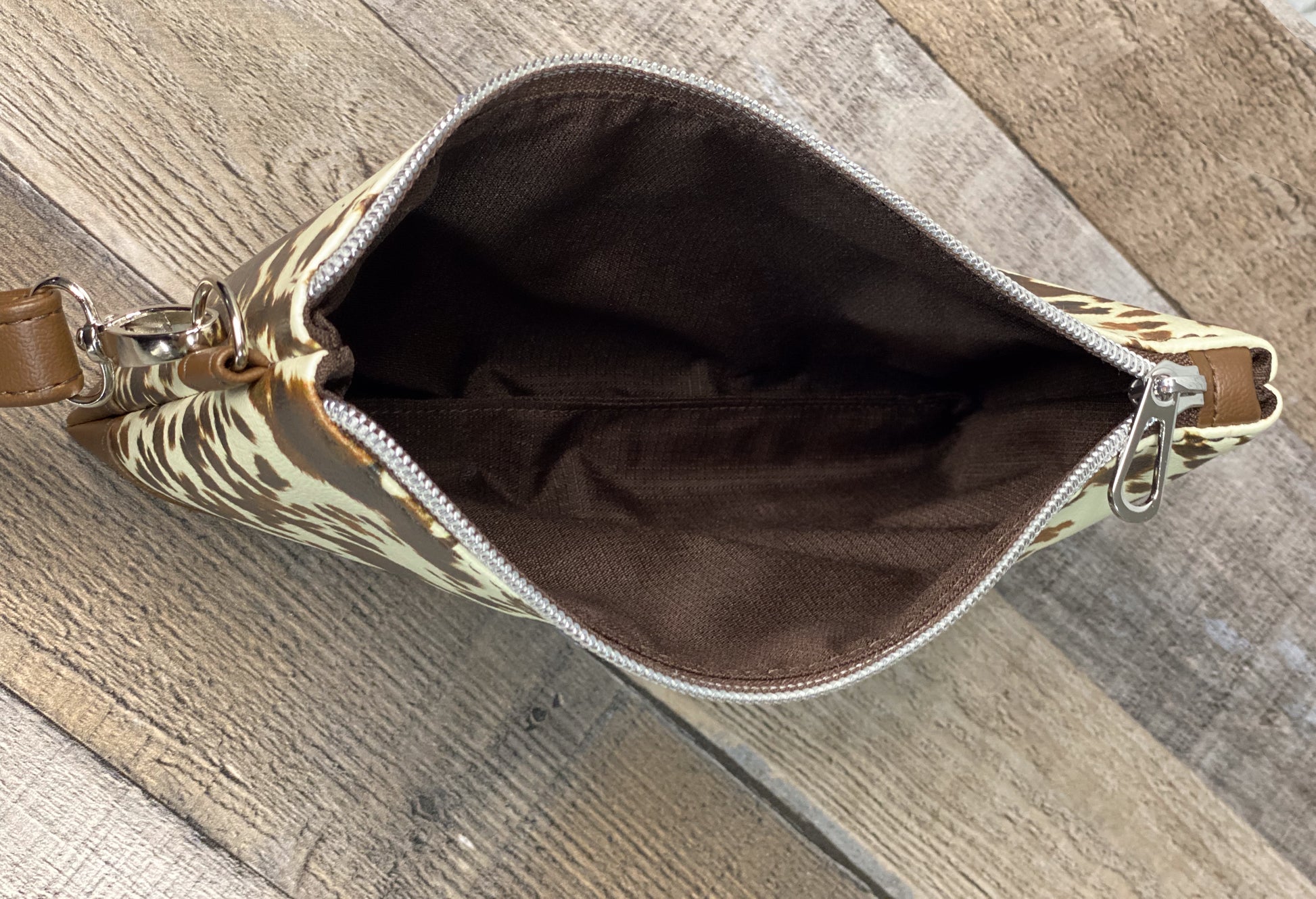 Cow print wristlet brown interior view. 