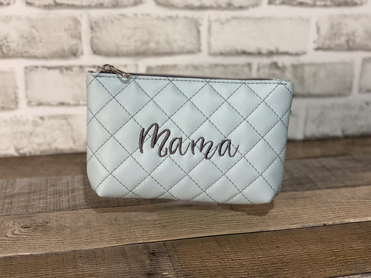 Baby blue quilted pouch with the word mama embroidered in the center. Front panel