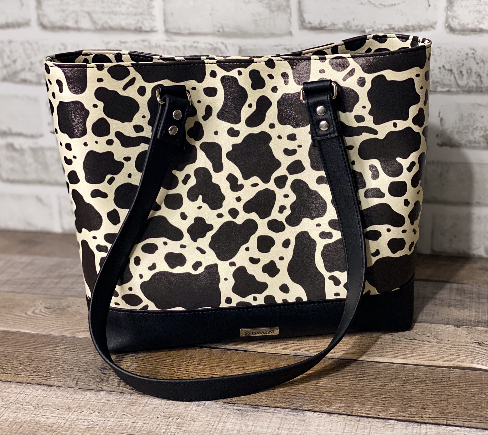 Black and white cow print big b tote bag front panel. 