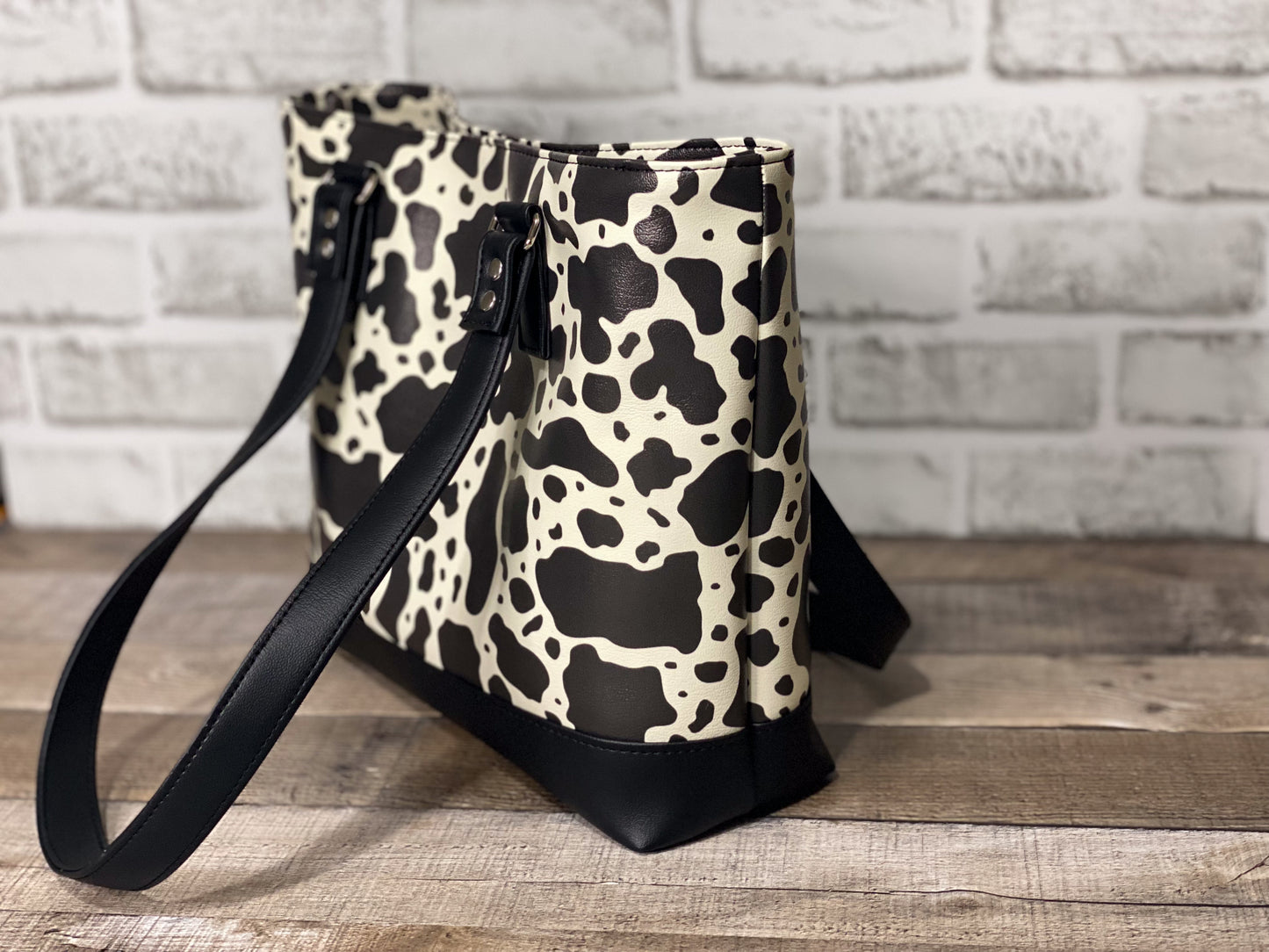 Black and white cow print big b tote bag side panel. 