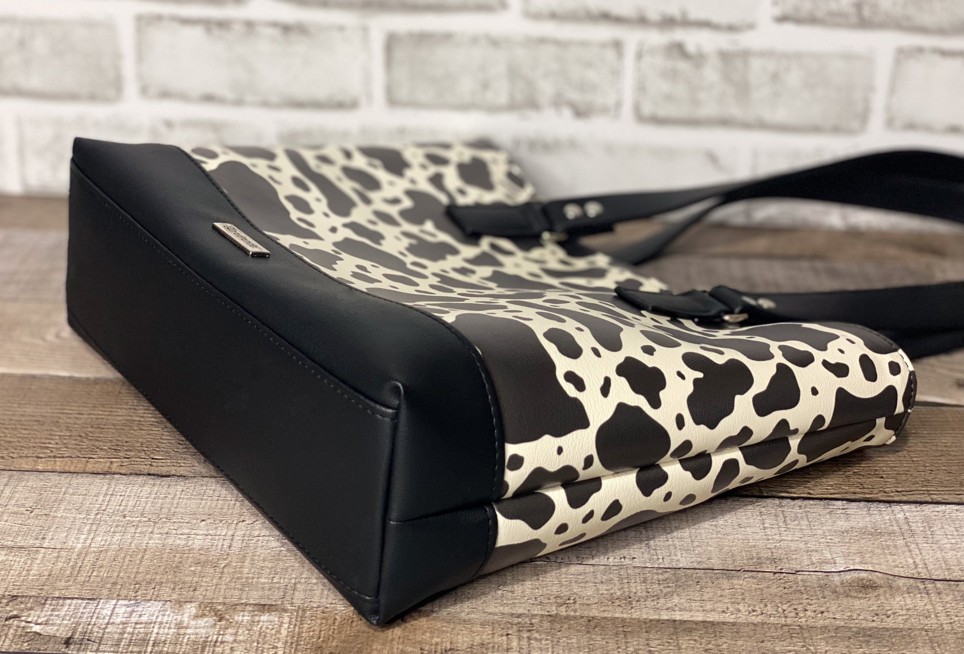 Black and white cow print big b tote bag bottom view. 