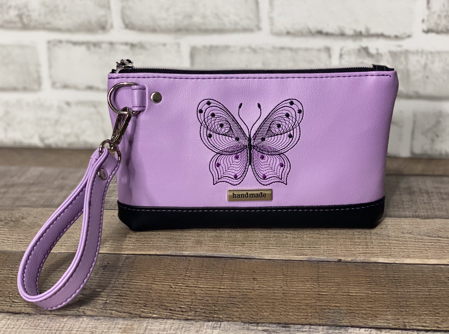 Lilac wristlet with embroidered butterfly front panel