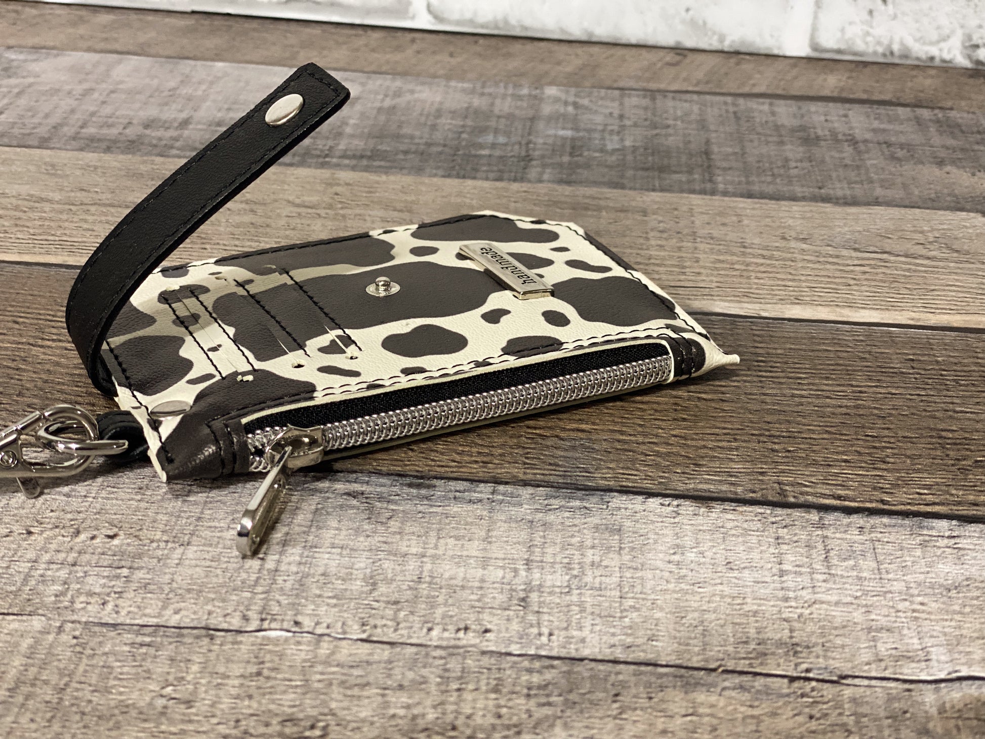 Black and white cow print purse pal wristlet wallet zipper panel view. 