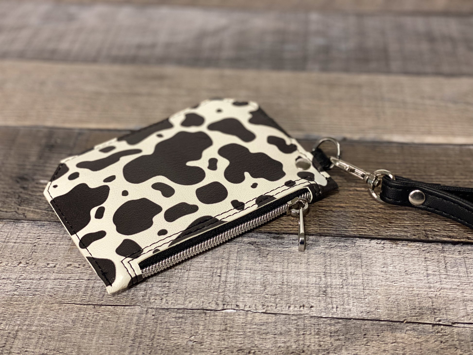 Black and white cow print purse pal wristlet wallet back panel view. 