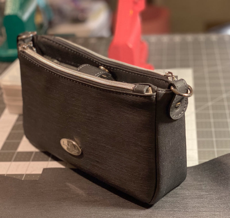 Grey faux leather crossbody bag with zipper compartments. 