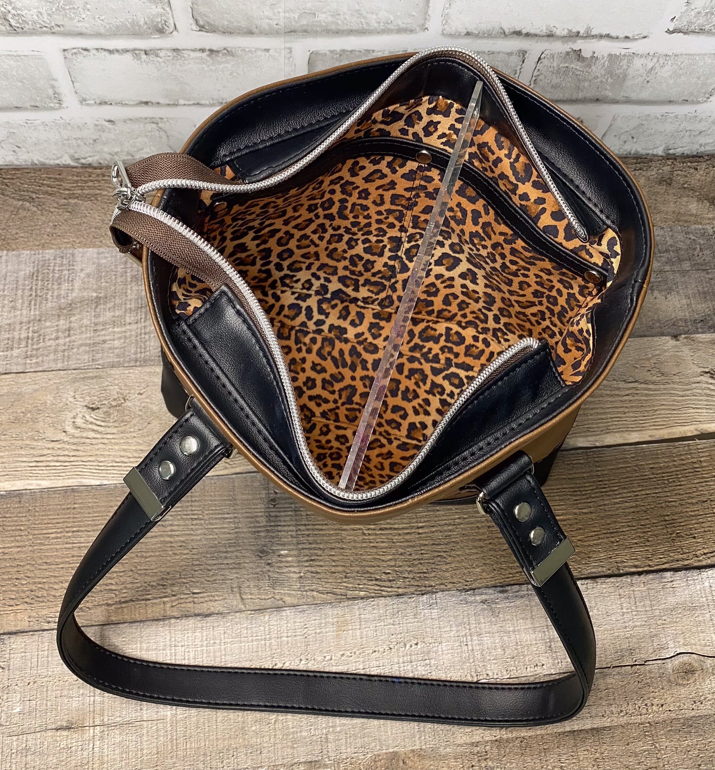 Brown faux leather handbag with leopard interior view showing the slip packet. 