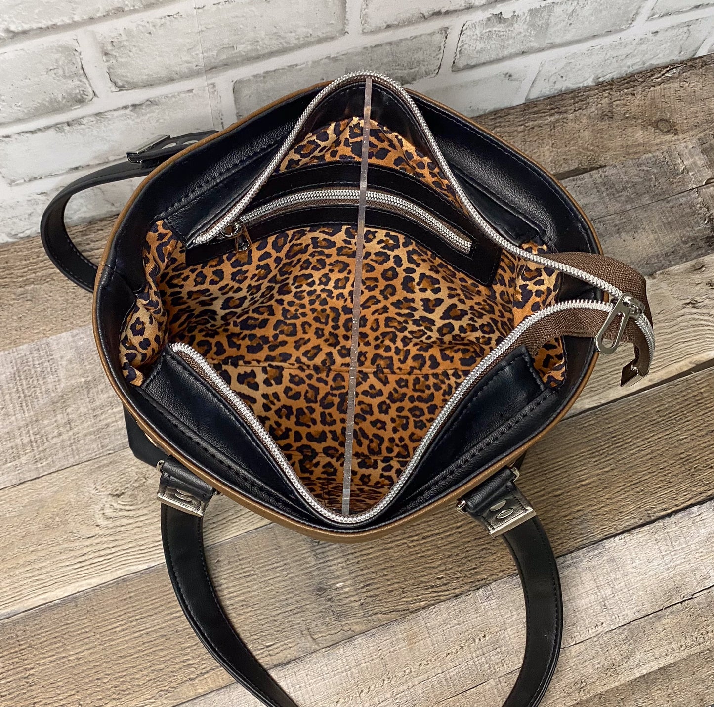 Brown faux leather handbag with leopard interior view showing the zipper packet. 